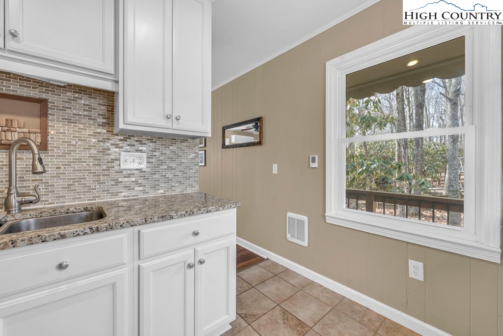 837 Pine Ridge Road Beech Mountain, NC 28604 - Photo 5 of 23 a kitchen with granite countertop white cabinets and a window