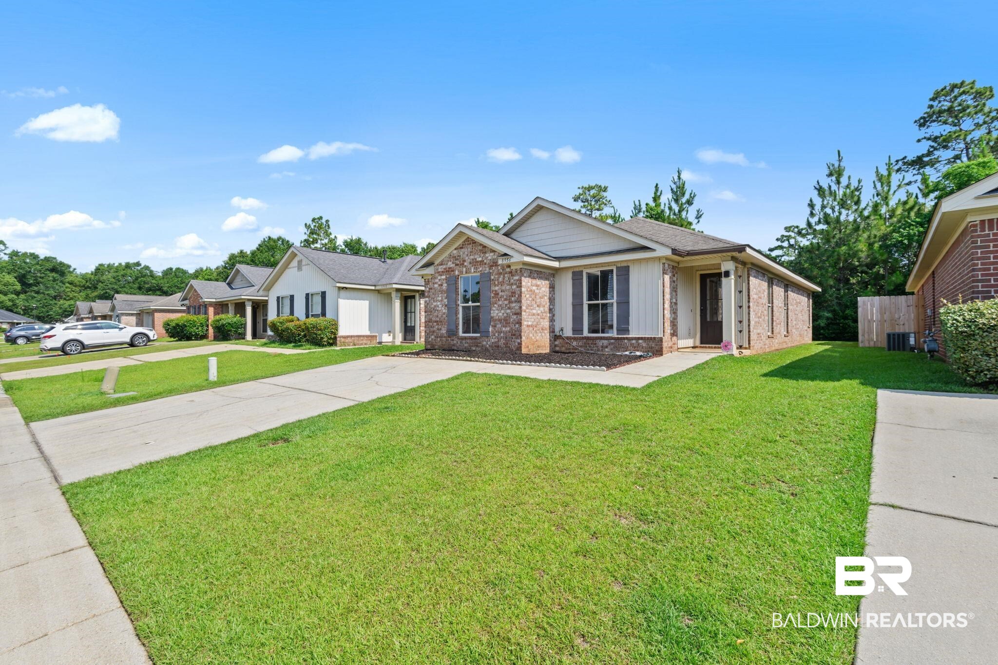 8956 Spring Grove North Mobile, AL 36695 - Photo 15 of 19 Single story home featuring brick siding, a front yard, cooling unit, and concrete driveway
