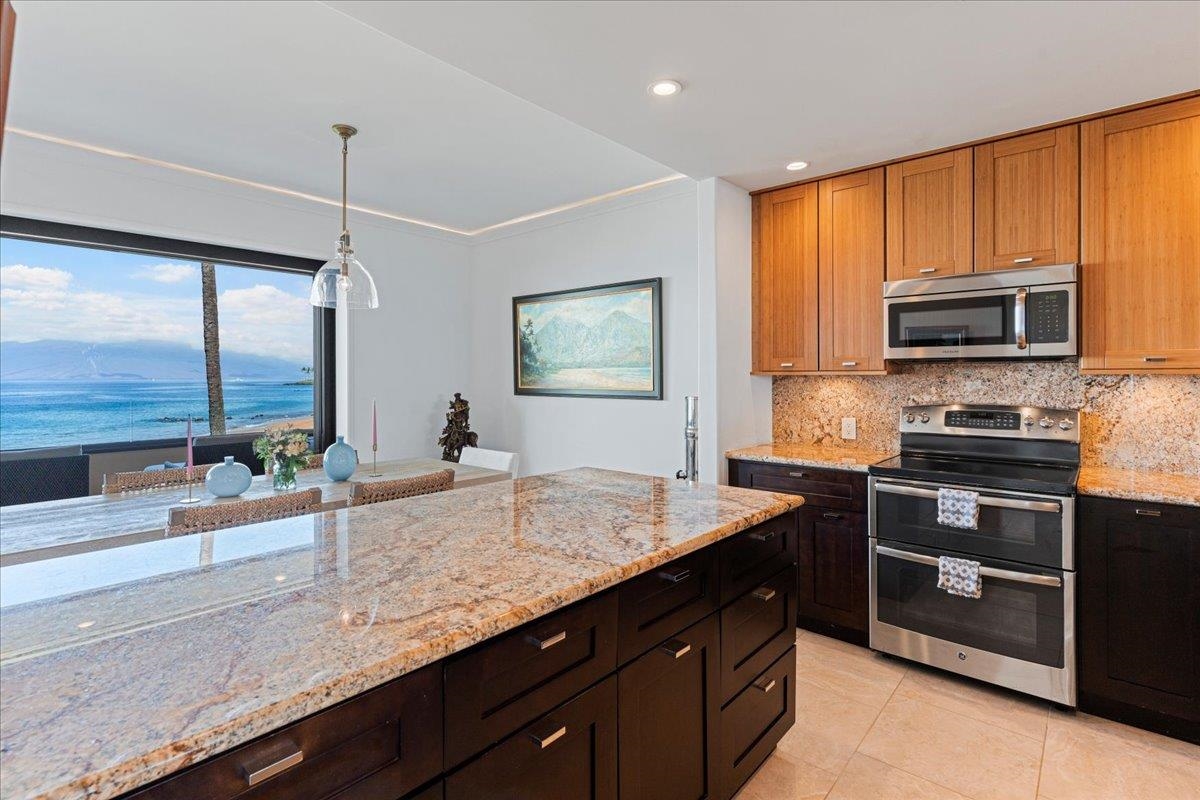 4850 Makena Alanui Road, Unit E205 Kihei, HI 96753 - Photo 12 of 45 a kitchen with sink cabinets and microwave