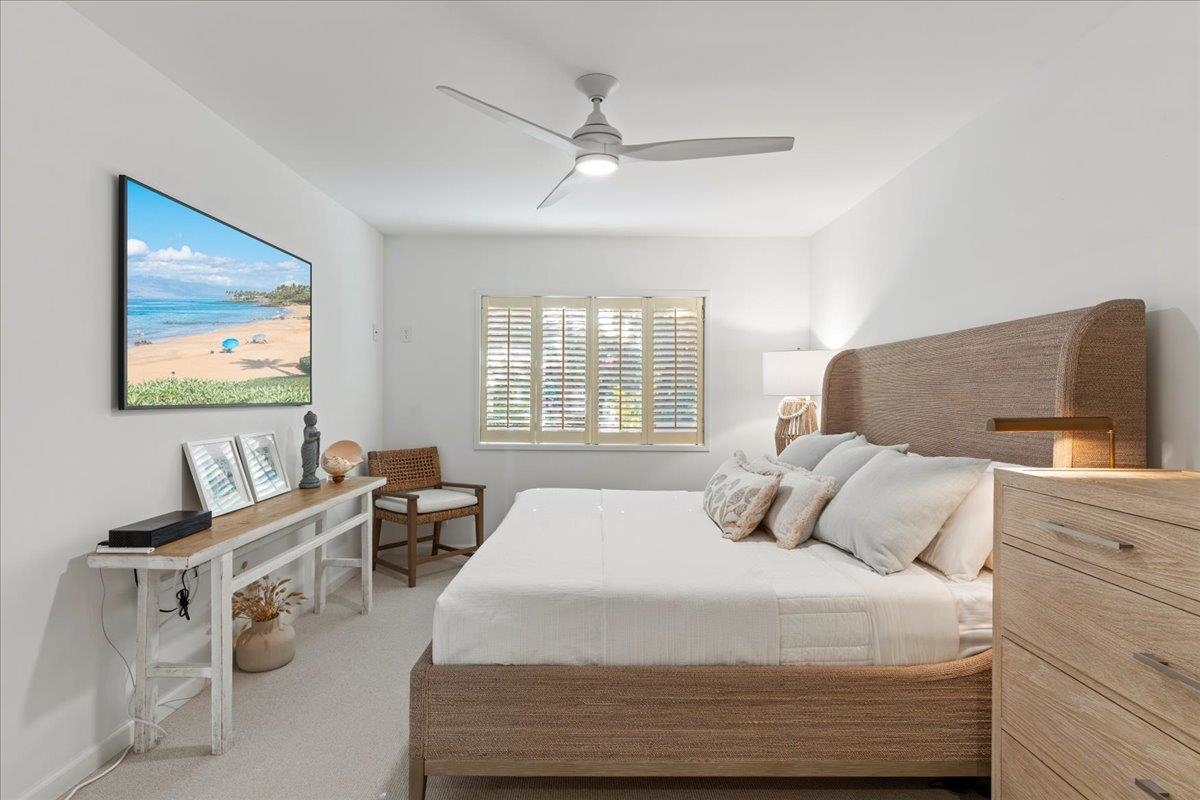 4850 Makena Alanui Road, Unit E205 Kihei, HI 96753 - Photo 20 of 45 a bedroom with a bed and wooden floor