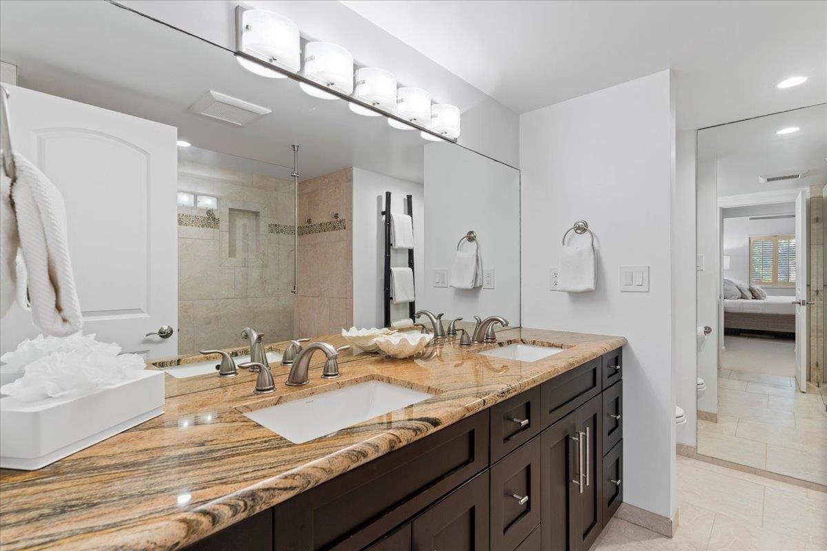 4850 Makena Alanui Road, Unit E205 Kihei, HI 96753 - Photo 21 of 45 a bathroom with a granite countertop sink and a mirror