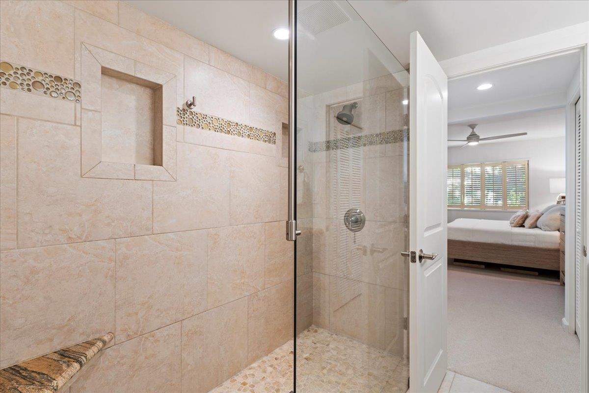 4850 Makena Alanui Road, Unit E205 Kihei, HI 96753 - Photo 22 of 45 a bathroom with a glass shower door and a bathtub