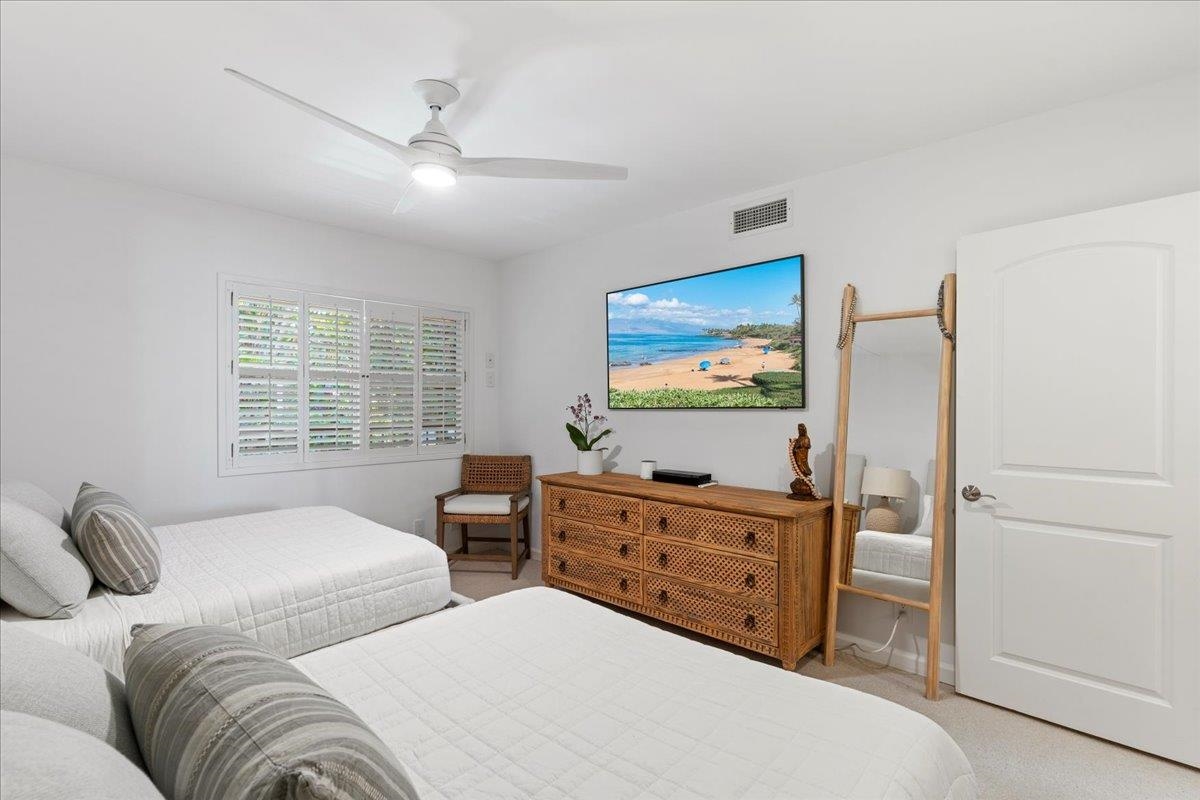 4850 Makena Alanui Road, Unit E205 Kihei, HI 96753 - Photo 26 of 45 a bedroom with two bed and a flat screen tv