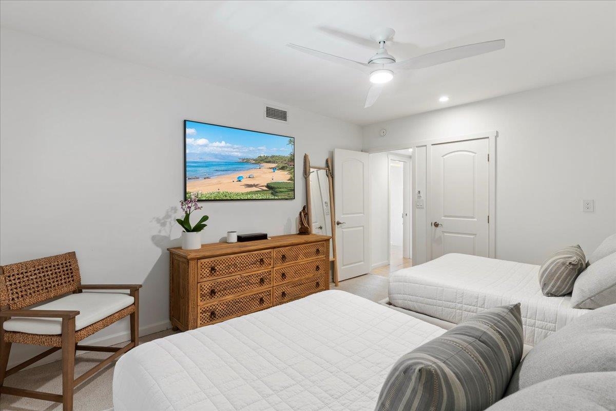4850 Makena Alanui Road, Unit E205 Kihei, HI 96753 - Photo 27 of 45 a bedroom with a large bed and a flat tv screen on dresser