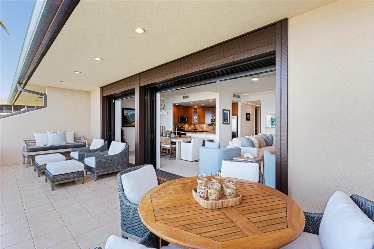 4850 Makena Alanui Road, Unit E205 Kihei, HI 96753 - Photo 29 of 45 a dining room with couches chairs and a dining table with wooden floor