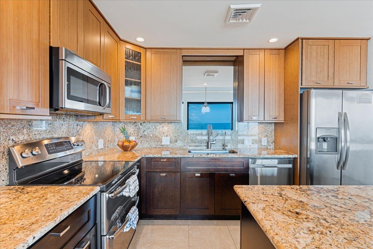 4850 Makena Alanui Road, Unit E205 Kihei, HI 96753 - Photo 7 of 45 a kitchen with stainless steel appliances granite countertop a sink stove and refrigerator