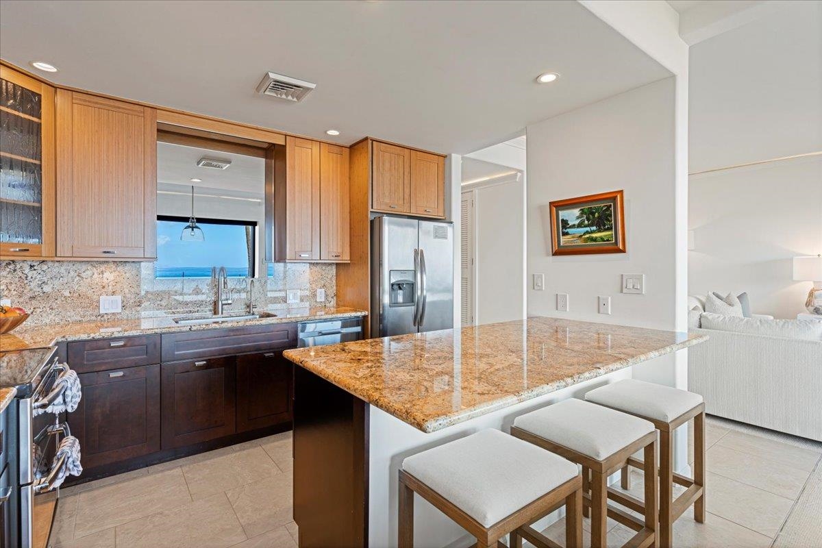 4850 Makena Alanui Road, Unit E205 Kihei, HI 96753 - Photo 10 of 45 a kitchen with a table chairs sink and cabinets