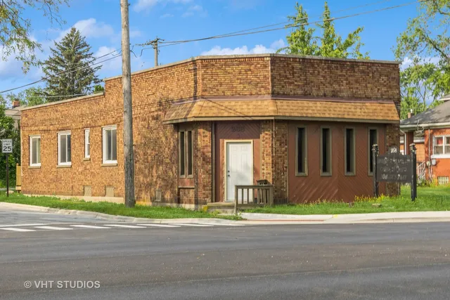 a view of a brick house with a yard next to a road
