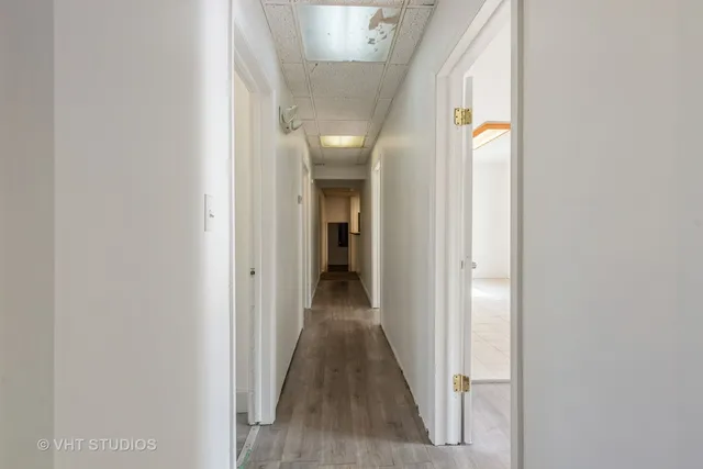 a view of a hallway with wooden floor