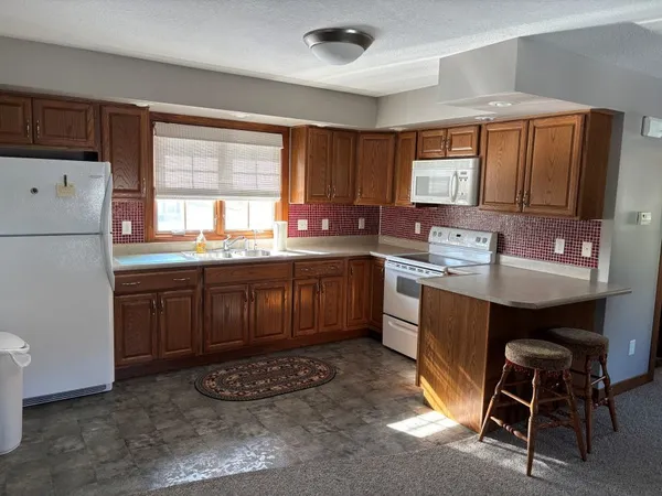 a kitchen with a sink stove and white refrigerator