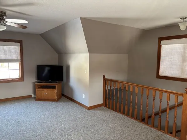 a living room with stairs and a flat screen tv