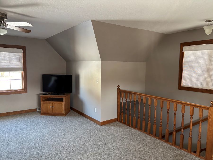 206 South Cherry Street Crescent City, IL 60928 - Photo 5 of 13 a living room with stairs and a flat screen tv