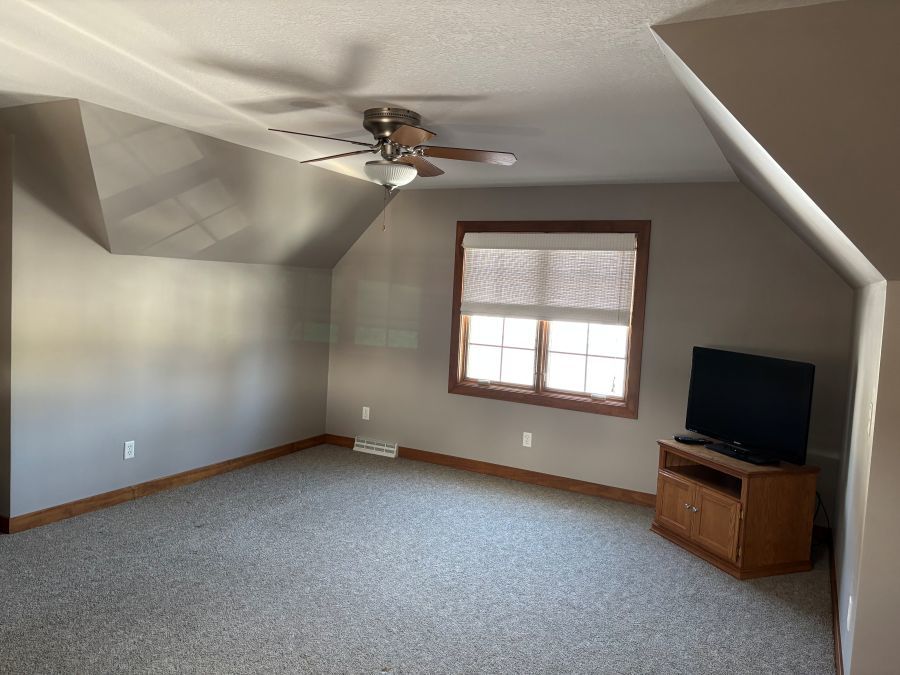 206 South Cherry Street Crescent City, IL 60928 - Photo 7 of 13 en empty room with windows and ceiling fan