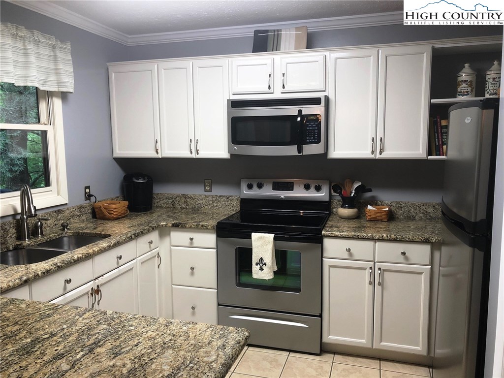 257 Cameron Terrace Boone, NC 28607 - Photo 11 of 42 a kitchen with stainless steel appliances granite countertop a stove a sink and a microwave