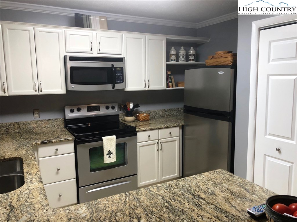 257 Cameron Terrace Boone, NC 28607 - Photo 12 of 42 a kitchen with stainless steel appliances granite countertop a stove a microwave and a refrigerator