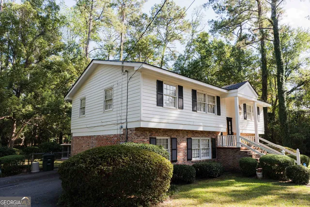 a view of a chair and table in backyard of the house