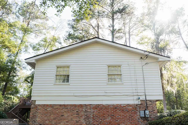 a view of a chair and table in backyard of the house