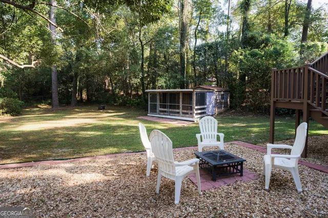 a view of a house with backyard and sitting area