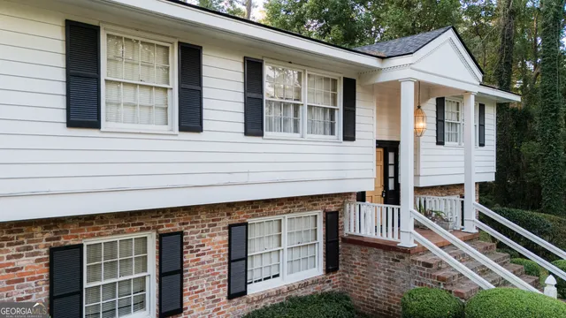 a view of a house with backyard and sitting area
