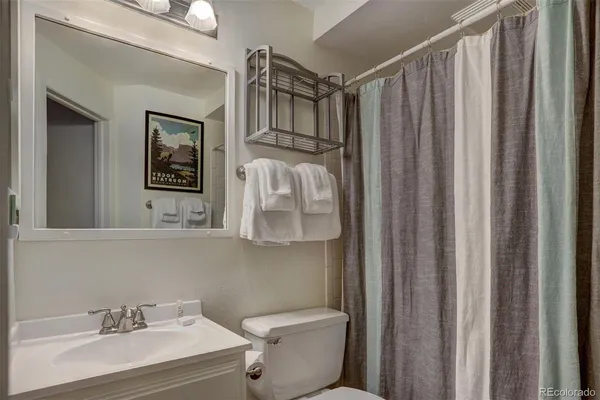 a bathroom with a sink a toilet and shower curtain