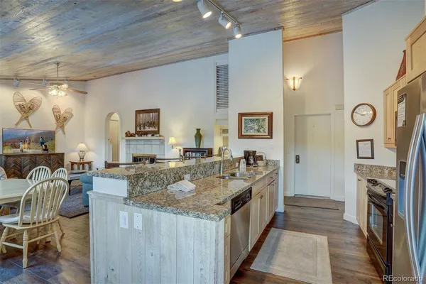 a large kitchen with granite countertop a large island in the center