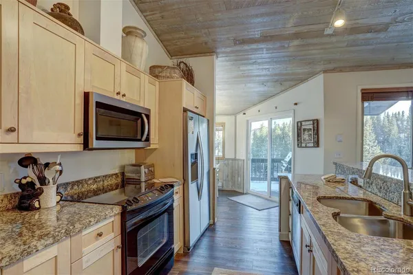 a kitchen with granite countertop a sink and a stove top oven