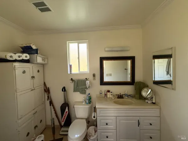 a bathroom with a granite countertop toilet sink and mirror