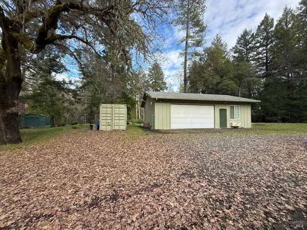 a front view of a house with a yard and a tree