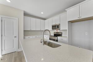 2760 River Meadow Spring Hope, NC 27882 - Photo 12 of 42 a kitchen with granite countertop a sink stove and refrigerator