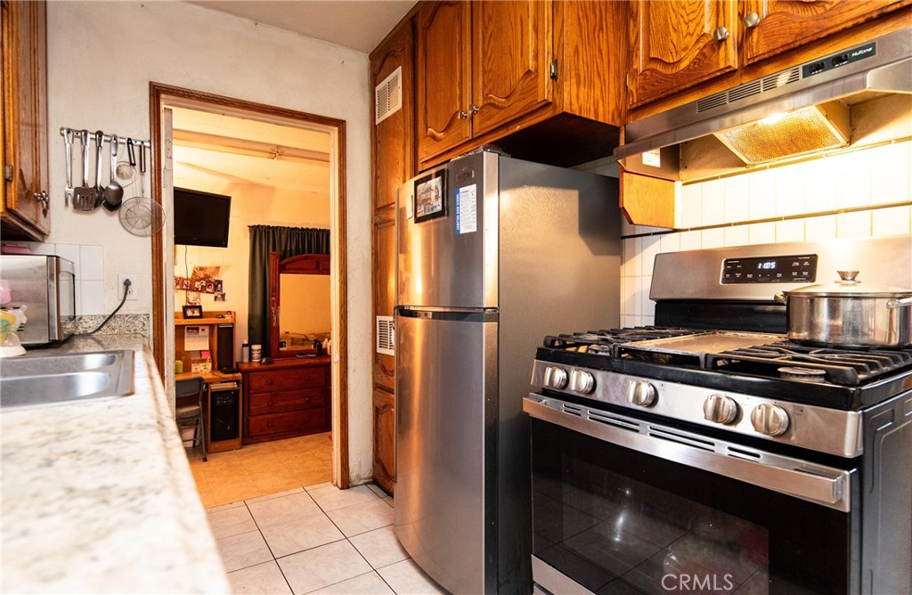 14527 Corlett Avenue Compton, CA 90220 - Photo 16 of 30 a kitchen with stainless steel appliances granite countertop a stove and a refrigerator