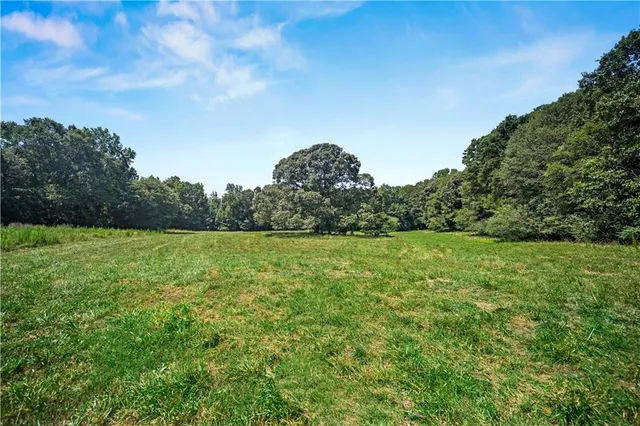 a view of a green field with wooden fence