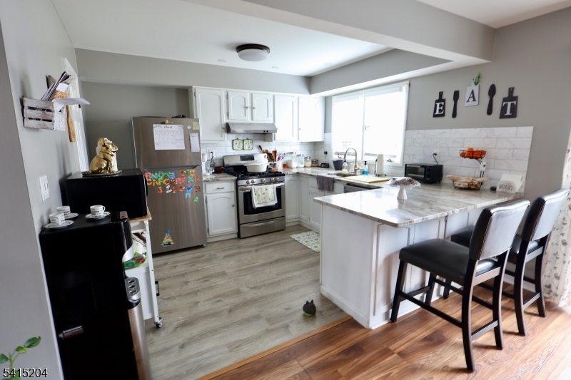 4 Sickle Street Dover, NJ 07801 - Photo 35 of 45 a kitchen with a refrigerator a stove a sink and dishwasher with wooden floor