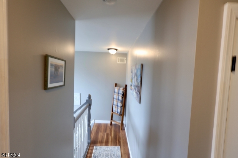 4 Sickle Street Dover, NJ 07801 - Photo 10 of 45 a view of a hallway with wooden floor and a bathroom