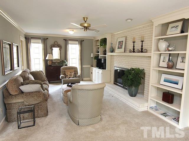 8013 Shellnut Road Raleigh, NC 27615 - Photo 12 of 25 a living room with furniture a fireplace and a flat screen tv