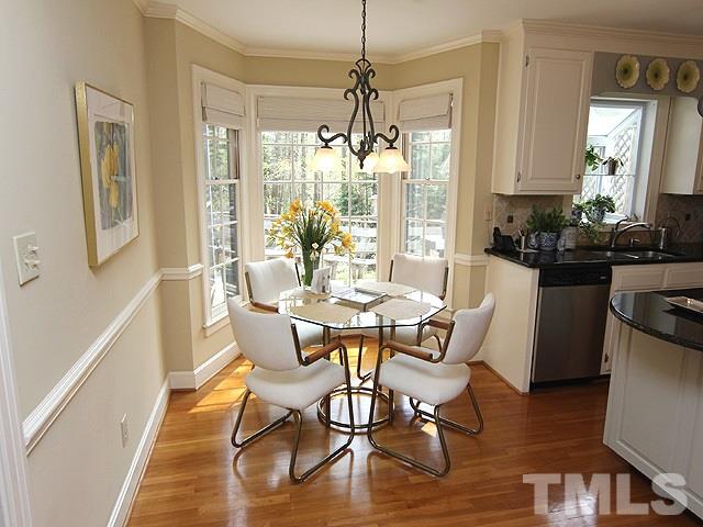 8013 Shellnut Road Raleigh, NC 27615 - Photo 10 of 25 a dining room with wooden floor a chandelier a glass table and chairs