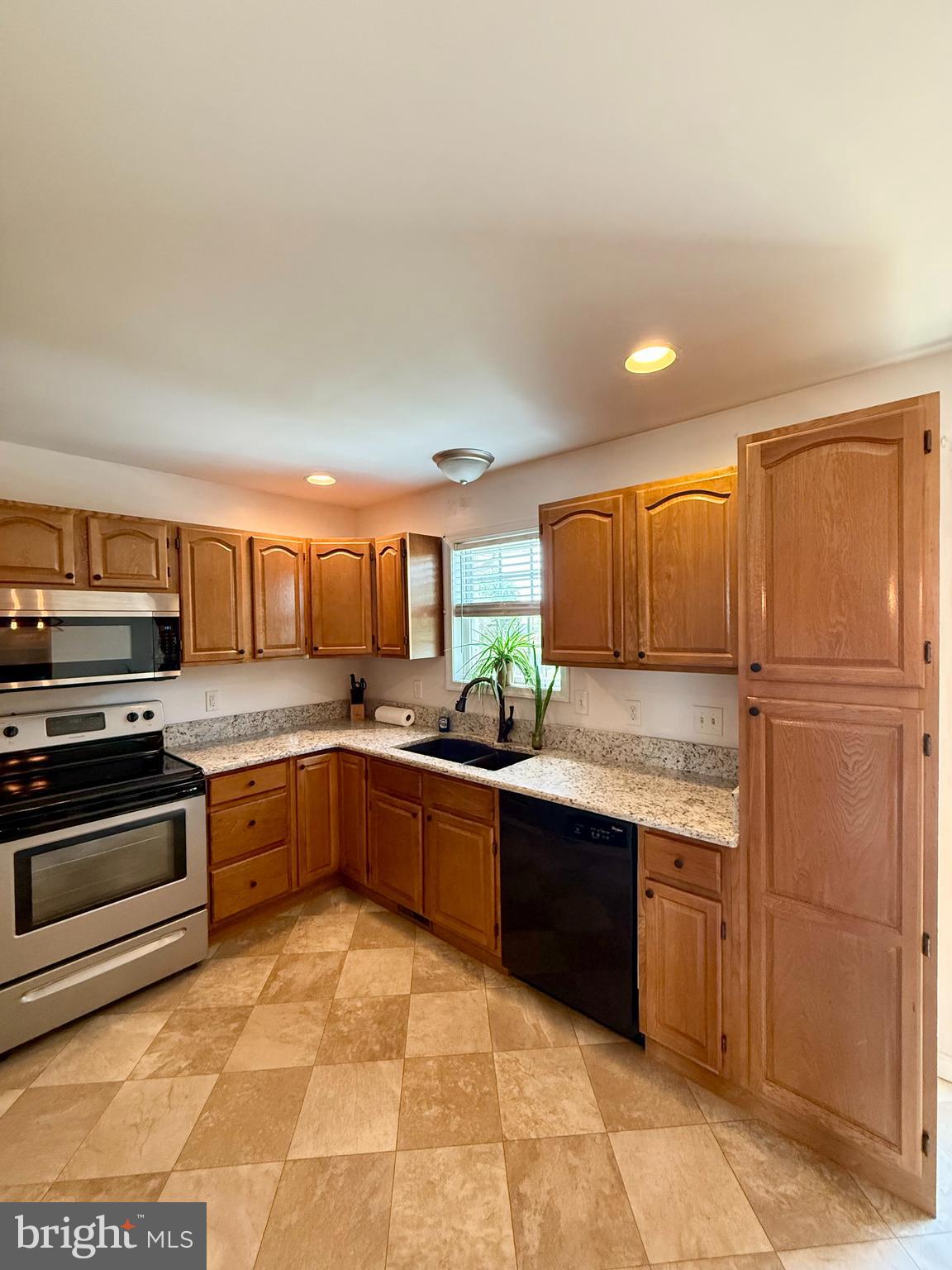 11684 Kensington Way Laurel, DE 19956 - Photo 15 of 43 a large kitchen with stainless steel appliances granite countertop a stove top oven a sink dishwasher and a refrigerator