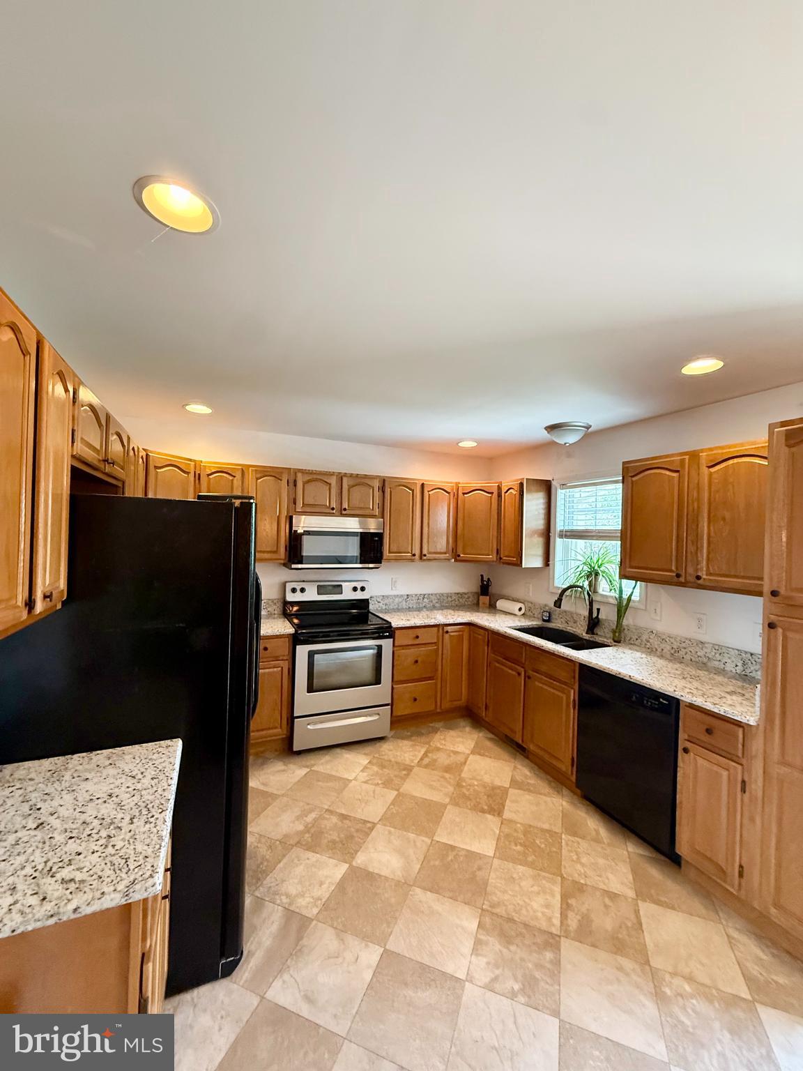 11684 Kensington Way Laurel, DE 19956 - Photo 16 of 43 a kitchen with stainless steel appliances kitchen island granite countertop a refrigerator and a stove top oven