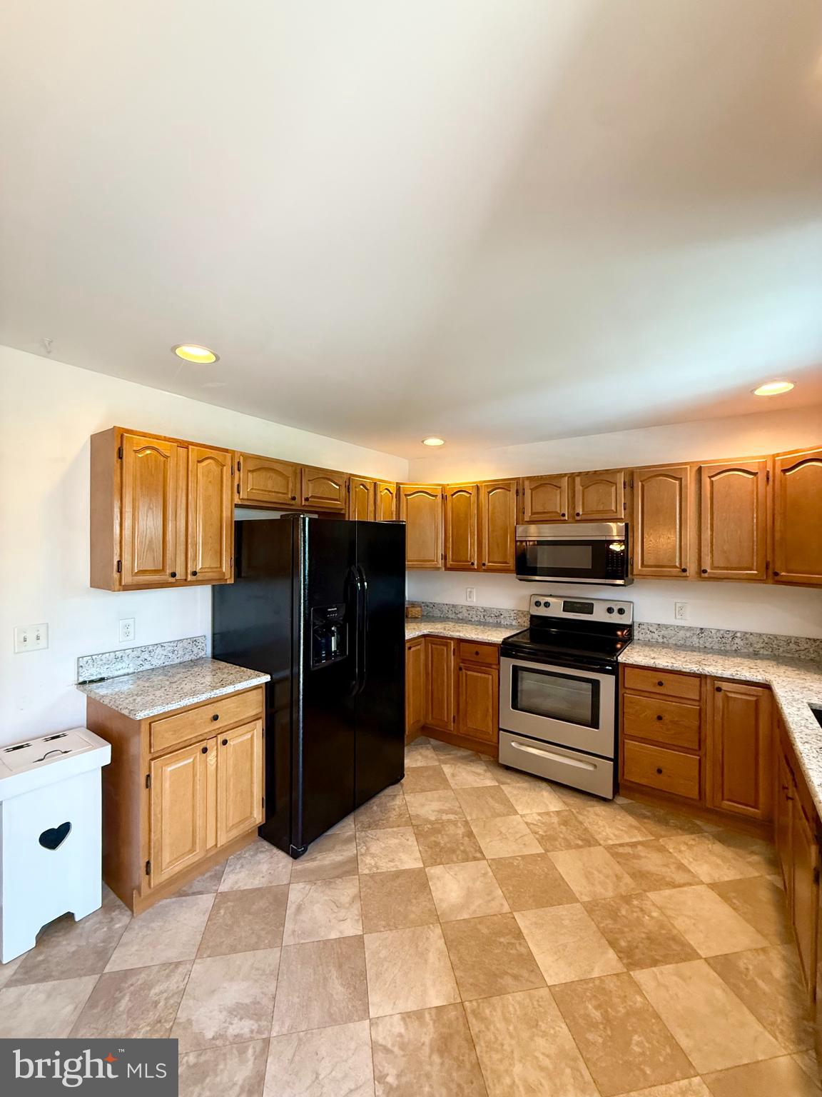 11684 Kensington Way Laurel, DE 19956 - Photo 17 of 43 a kitchen with stainless steel appliances kitchen island granite countertop a refrigerator and a stove top oven