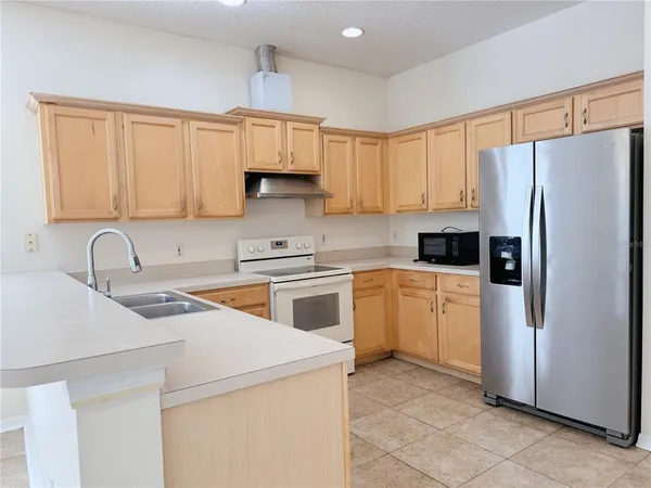 a kitchen with stainless steel appliances granite countertop a refrigerator sink and cabinets