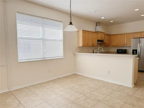 a kitchen with stainless steel appliances granite countertop a sink a stove a refrigerator and a window