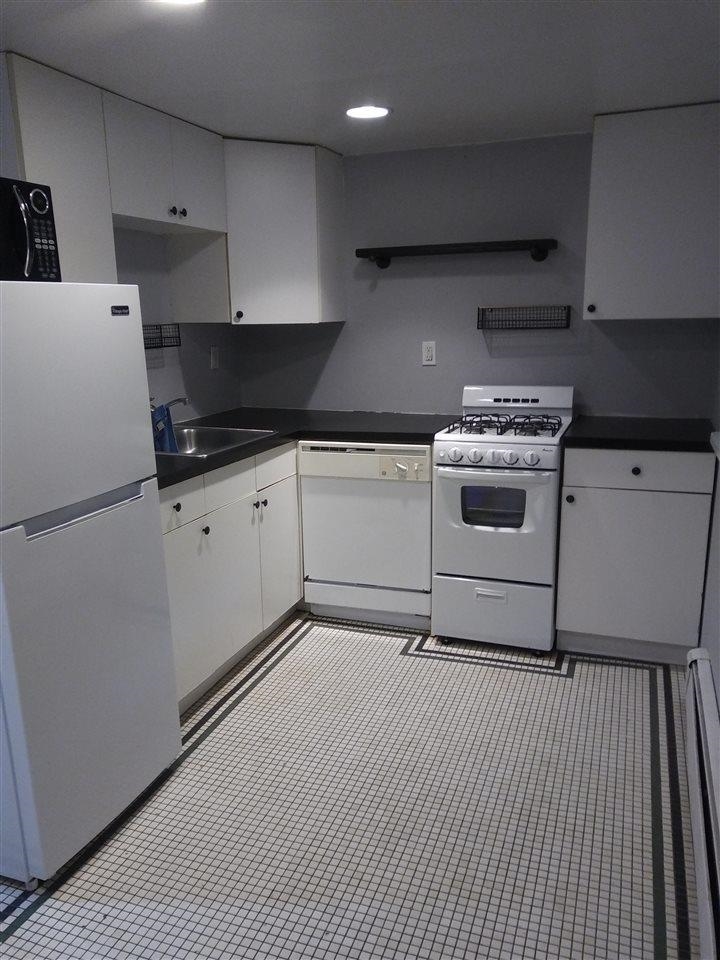 220 Garden Street, Unit 1(GRND) Hoboken, NJ 07030 - Photo 5 of 9 a white kitchen with granite countertop stainless steel appliances