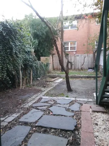 a view of a house with backyard and trees