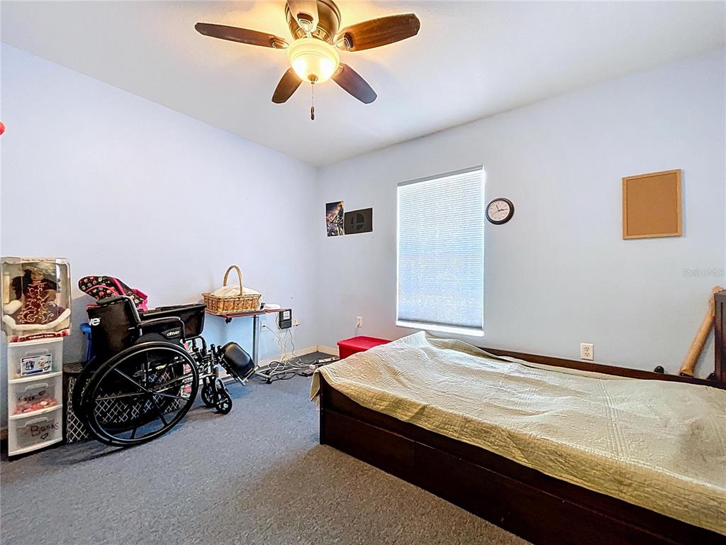 4372 Odin Street Spring Hill, FL 34608 - Photo 22 of 38 a bedroom with bed and a chandelier