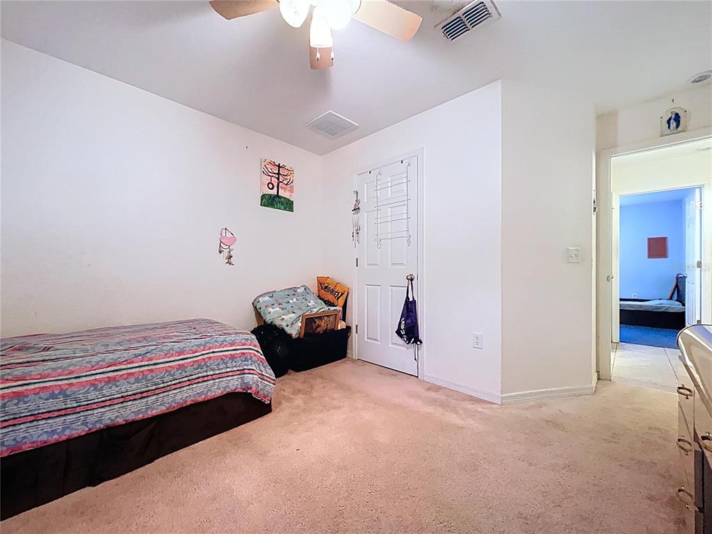4372 Odin Street Spring Hill, FL 34608 - Photo 25 of 38 a bedroom with furniture and a chandelier fan