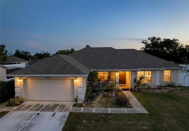a front view of house with yard and trees in the background