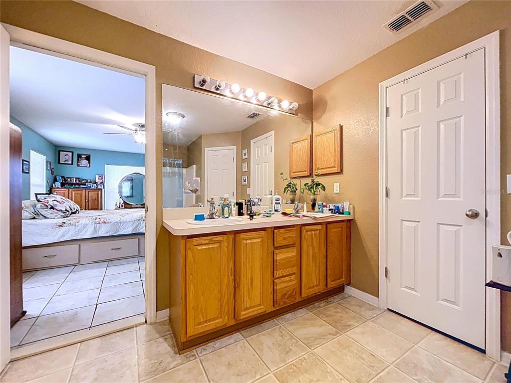 4372 Odin Street Spring Hill, FL 34608 - Photo 32 of 38 a large bathroom with a large mirror vanity and sink