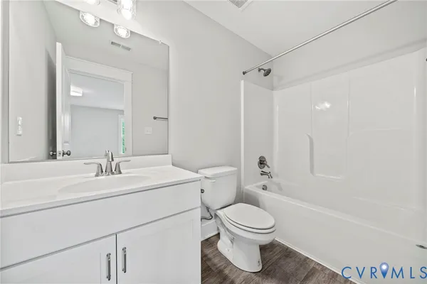 a bathroom with a toilet sink vanity tub and shower