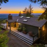 a roof deck with table and chairs with potted plants