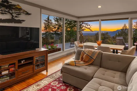 a living room with furniture a rug and a floor to ceiling window