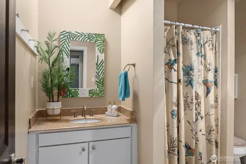 a bathroom with a granite countertop sink and a mirror